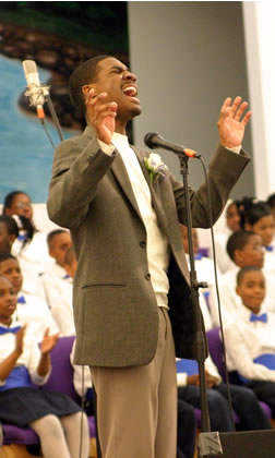 Choir director singing at microphone. 