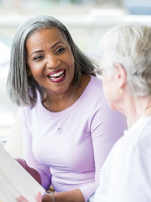 A picture of a woman smiling while discussing a book 